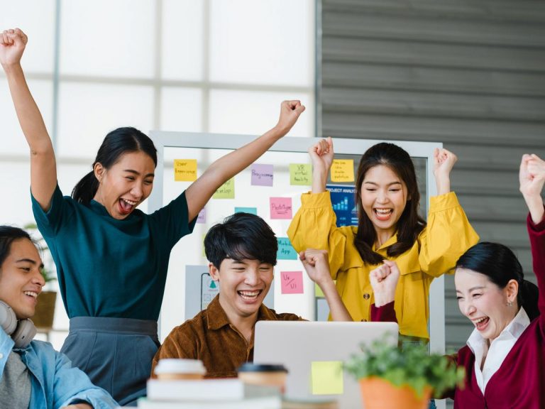 0500_1641535684-group-asia-young-creative-people-smart-casual-wear-discussing-business-celebrate-giving-five-after-dealing-feeling-happy-signing-contract-agreement-office-coworker-teamwork-concept