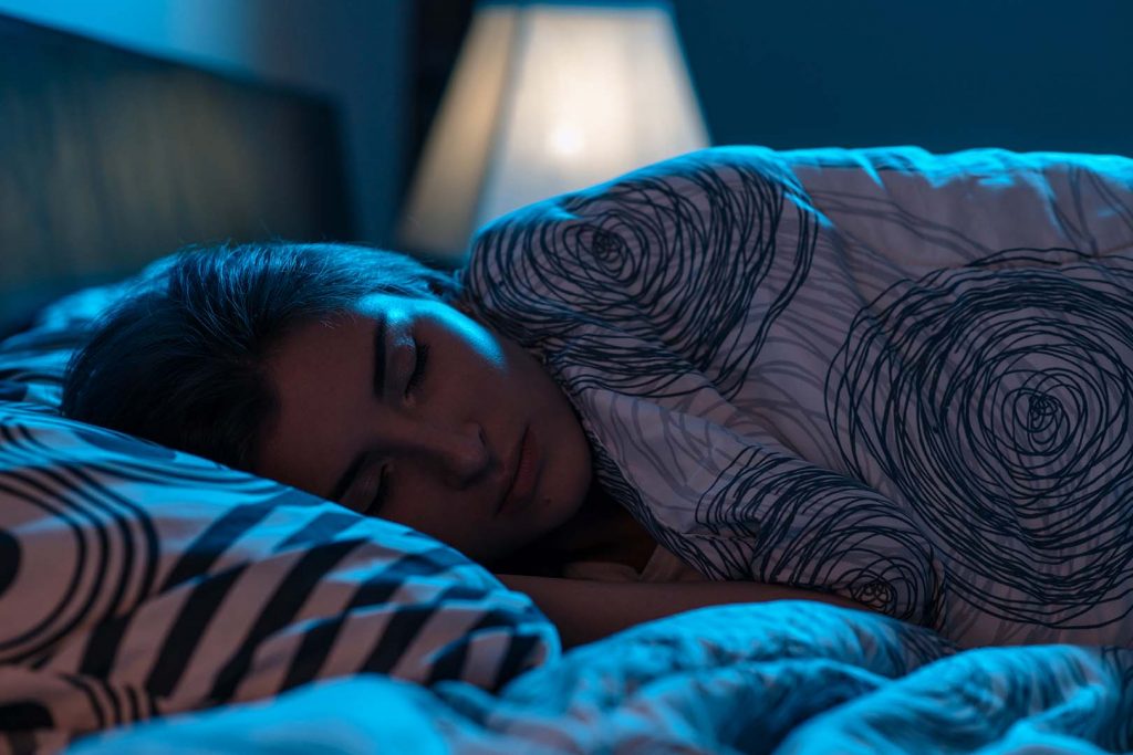 Young attractive Woman sleeping in a bed in a dark bedroom